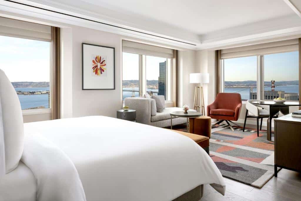Sovrum och sittgrupp med stora fönster på Four Seasons Hotel San Francisco at Embarcadero