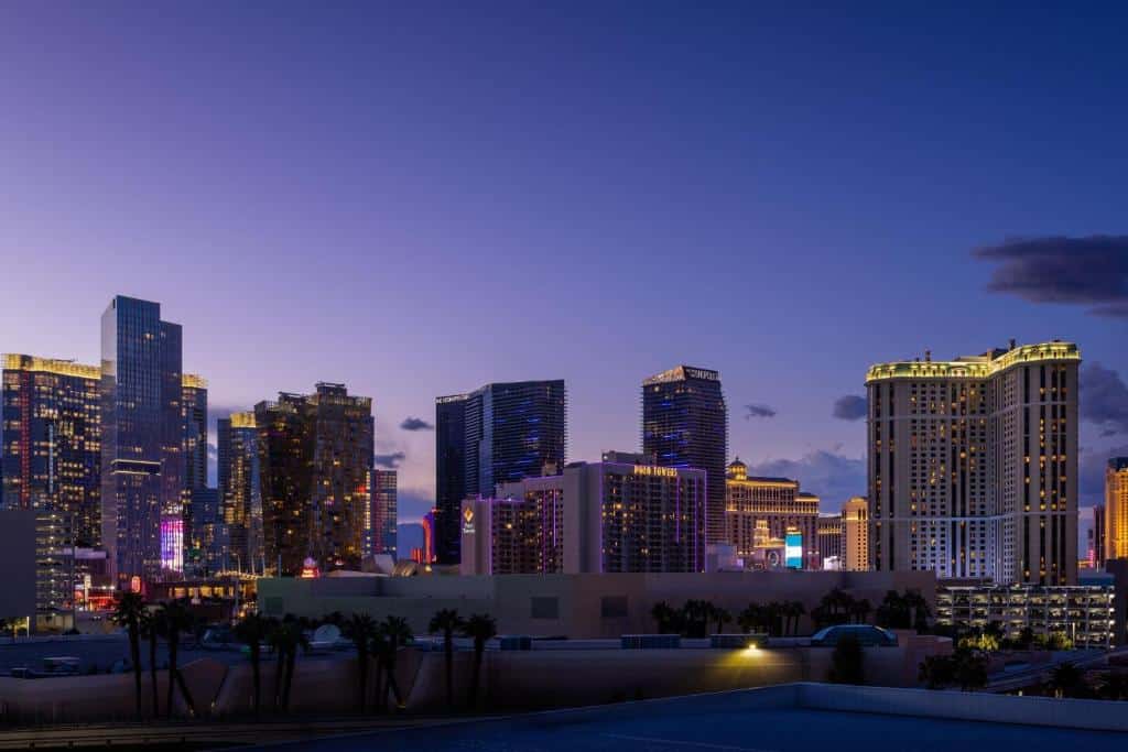 Utsikt över hotell i Las Vegas i skymningen med en palm i förgrunden
