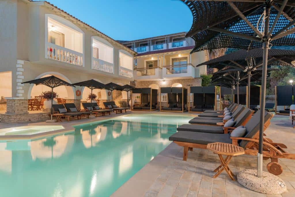 Upplyst pool och solstolar på Ino Hotel & Suites