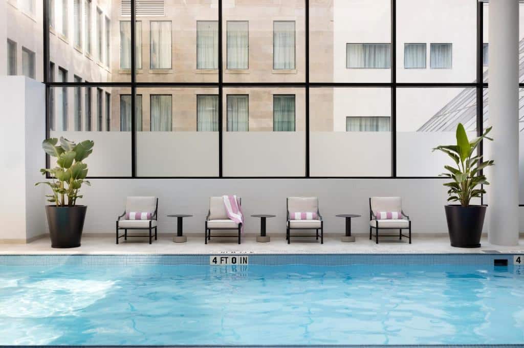 Inomhuspool med solstolar och stora fönster på The Langham, Boston