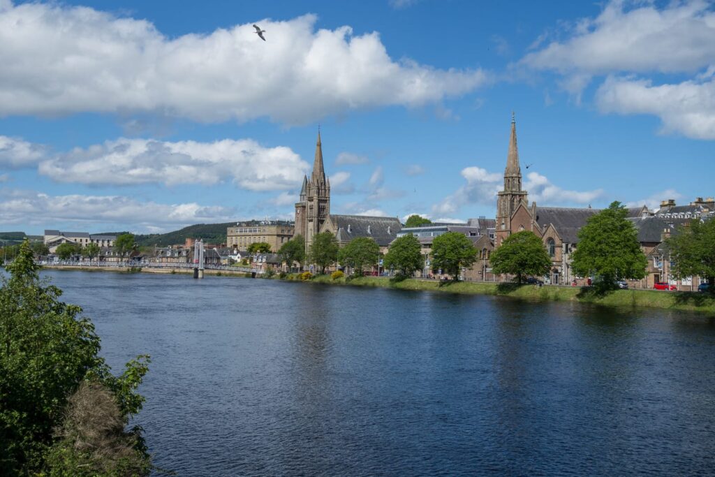 Byggnader och en kyrka vid River Ness i Inverness