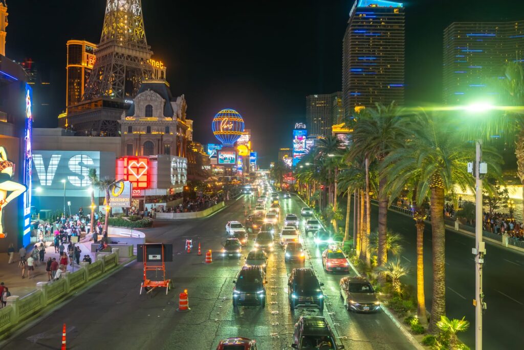 Trafik, palmer och upplysta hotell längs Las Vegas Strip på natten