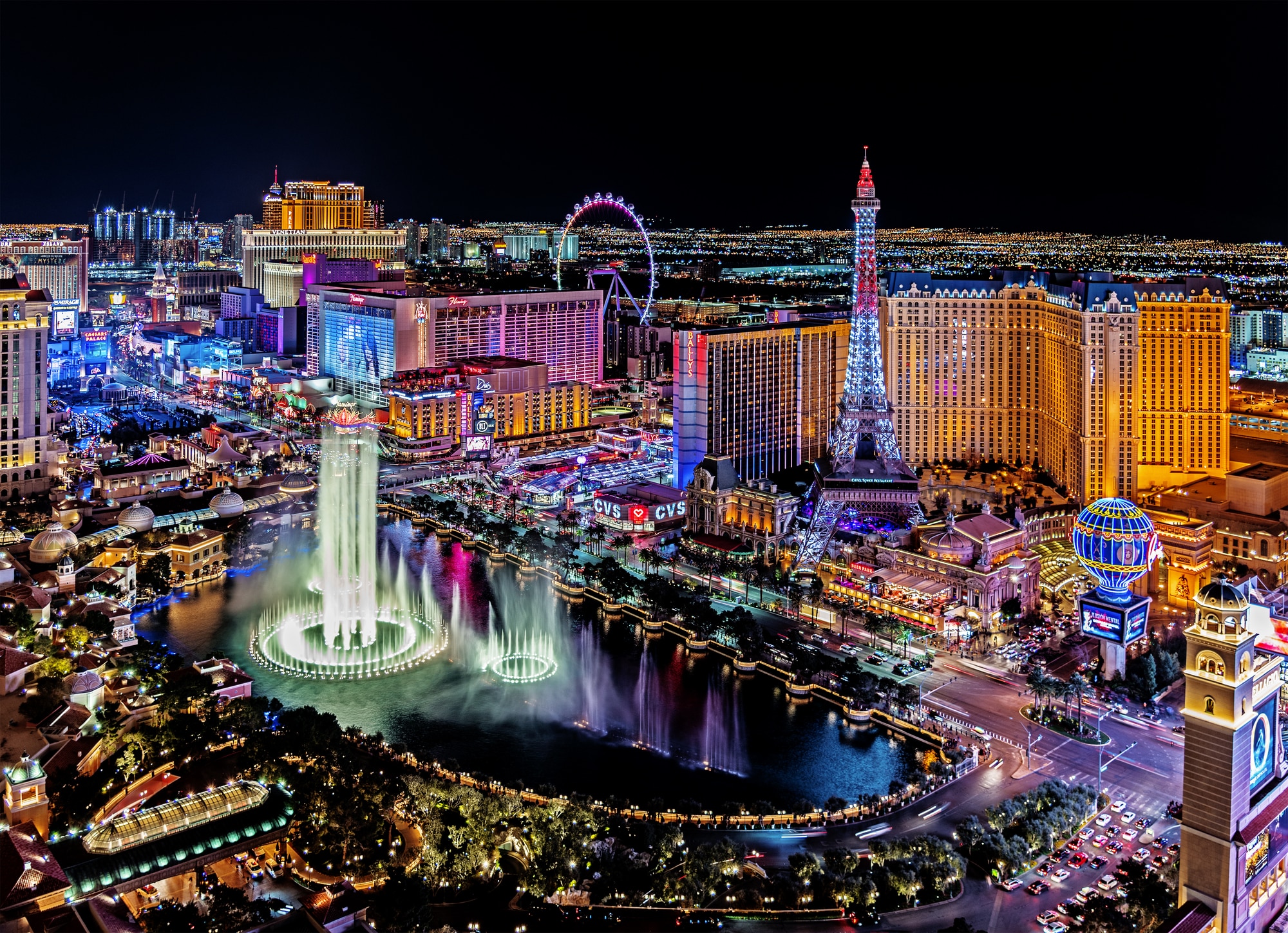 Flygvy över Bellagios fontäner och upplysta hotell längs Las Vegas Strip på natten