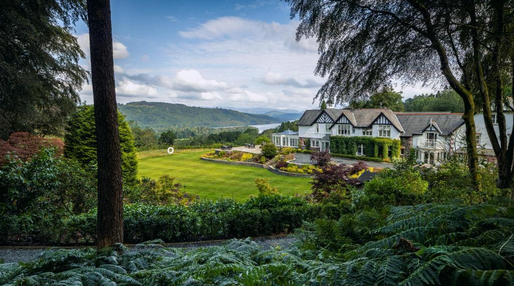 Linthwaite House Hotel sett över gräsmattan och en liten damm mellan träden