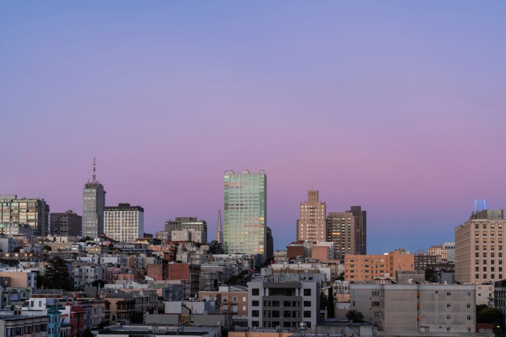Utsikt över San Franciscos byggnader och kullar under en rosa kvällshimmel
