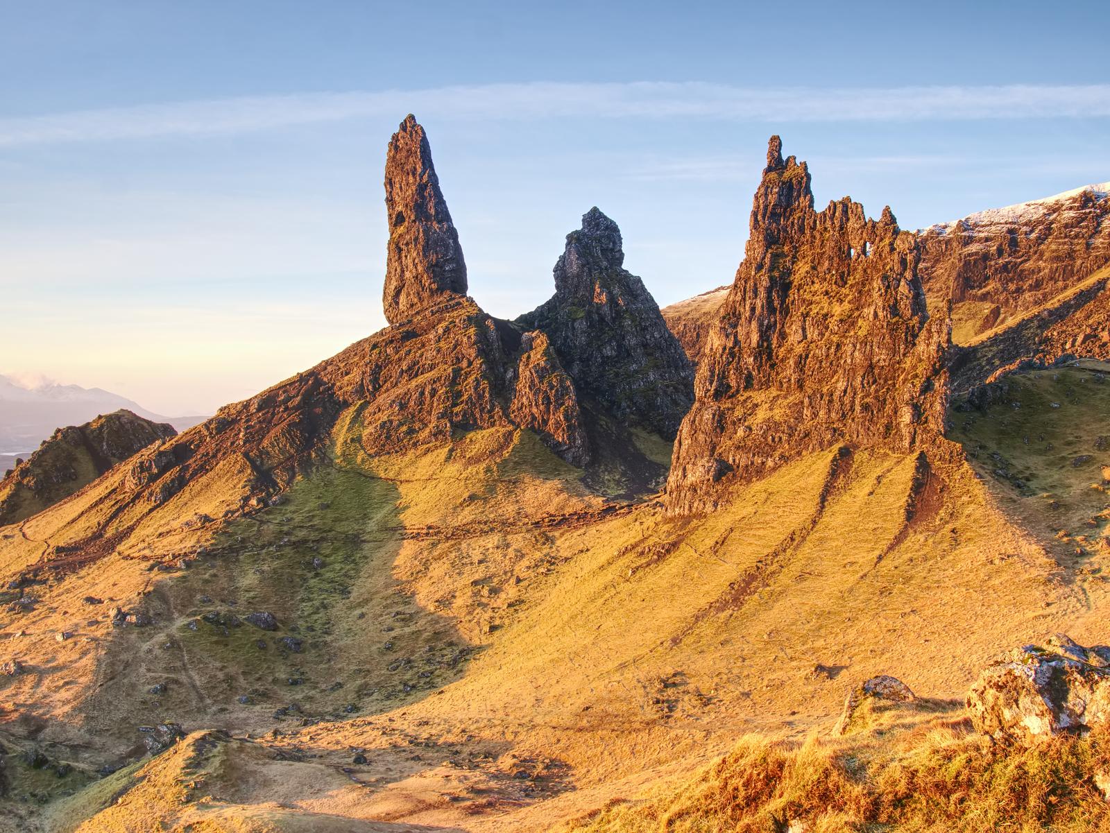 Klipptornen vid Old Man of Storr ovanför solbelysta sluttningar på Isle of Skye