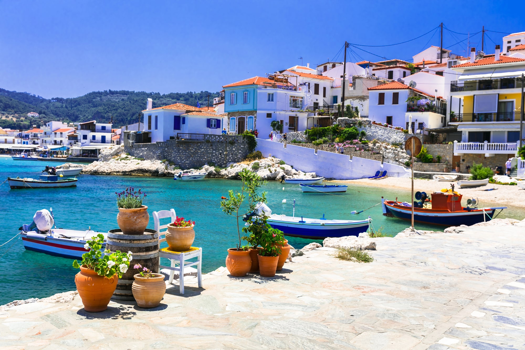 Båtar och vita hus vid en liten vik på Samos