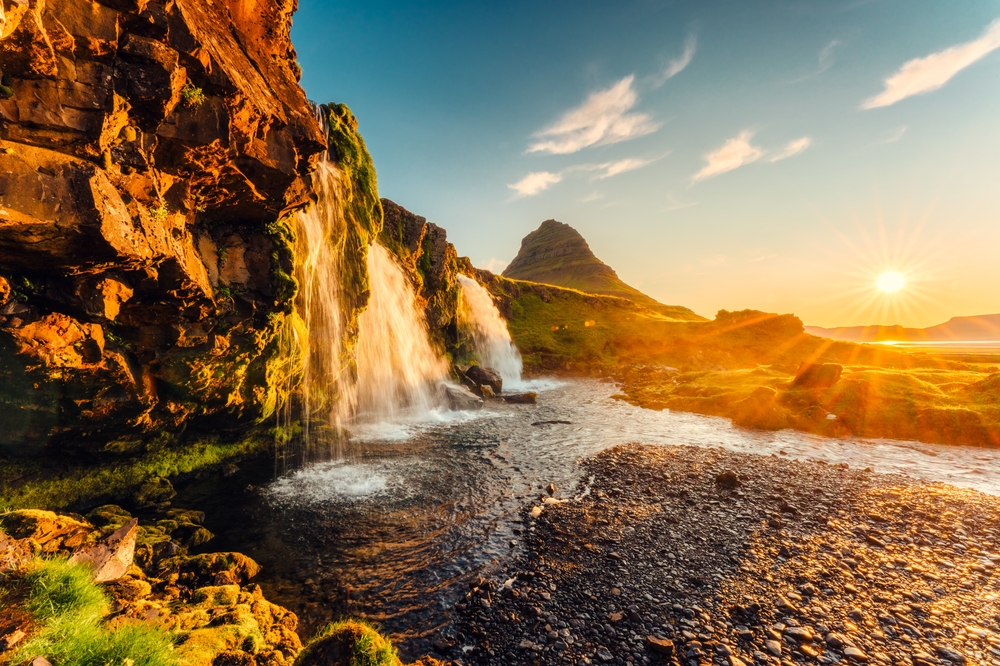 Berget Kirkjufell och vattenfallet Kirkjufellsfoss på Snæfellsnes i soluppgången
