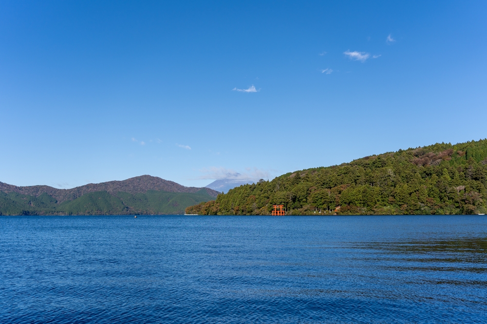 Den röda torii-porten vid sjön Ashi i Hakone med berget Fuji i bakgrunden