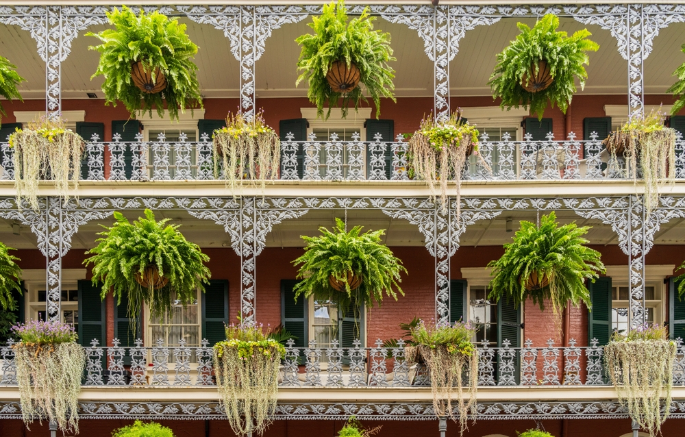 Hus med smidesbalkonger och hängande blomkorgar på Royal Street i French Quarter