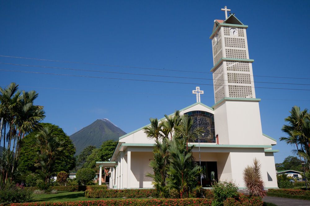 Kyrkan och parken i La Fortuna med vulkanen Arenal i bakgrunden
