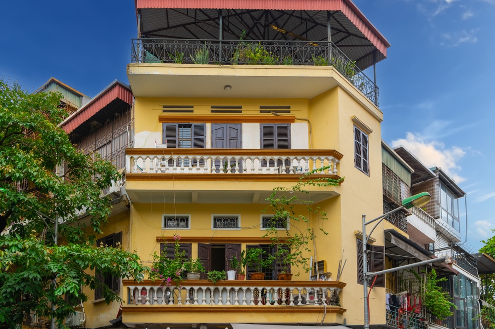 Smala, höga hus med växter på fasaden i Gamla kvarteren i Hanoi