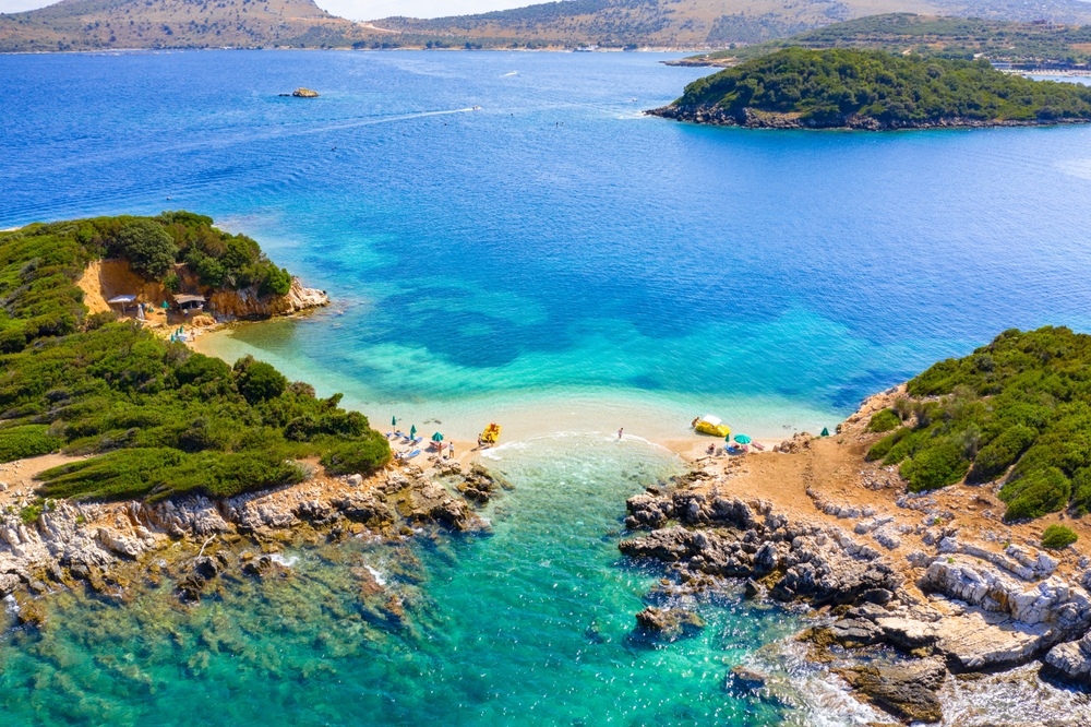 Stranden Bora Bora i Ksamil med de små öarna ute i vattnet