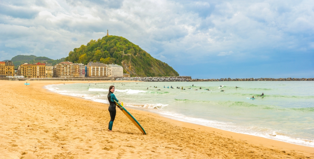 Surfare vid stranden Zurriola i stadsdelen Gros i San Sebastian