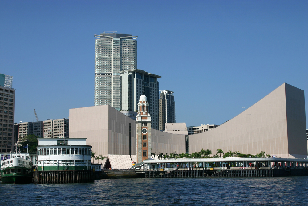 Tsim Sha Tsui sett från Victoria Harbour med klocktornet och färjeterminalen