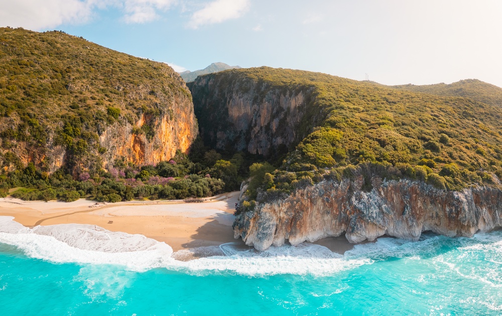 Flygfoto över stranden Gjipe och ravinen bakom den på Albanska rivieran