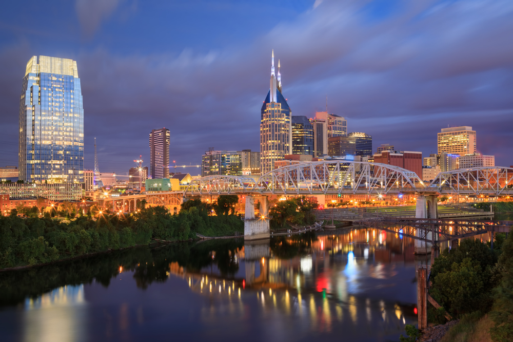 Nashvilles stadssiluett och gångbron John Seigenthaler Pedestrian Bridge över Cumberland River i gryningen