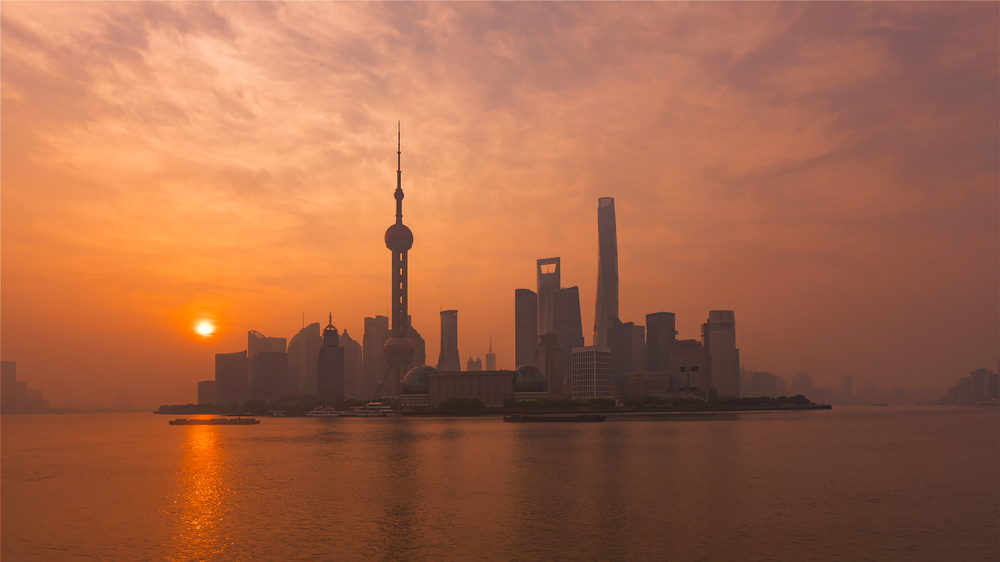 Lujiazuis stadssiluett sedd från The Bund i Shanghai i solnedgången
