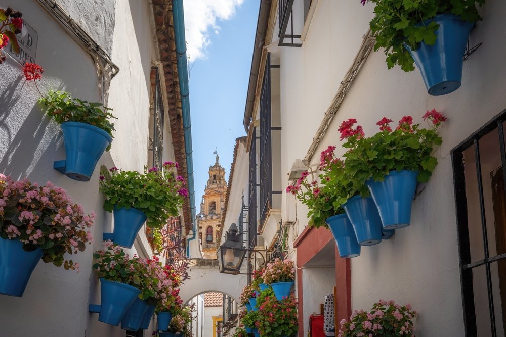 Calleja de las Flores i Judería i Córdoba med Mezquitas klocktorn i bakgrunden