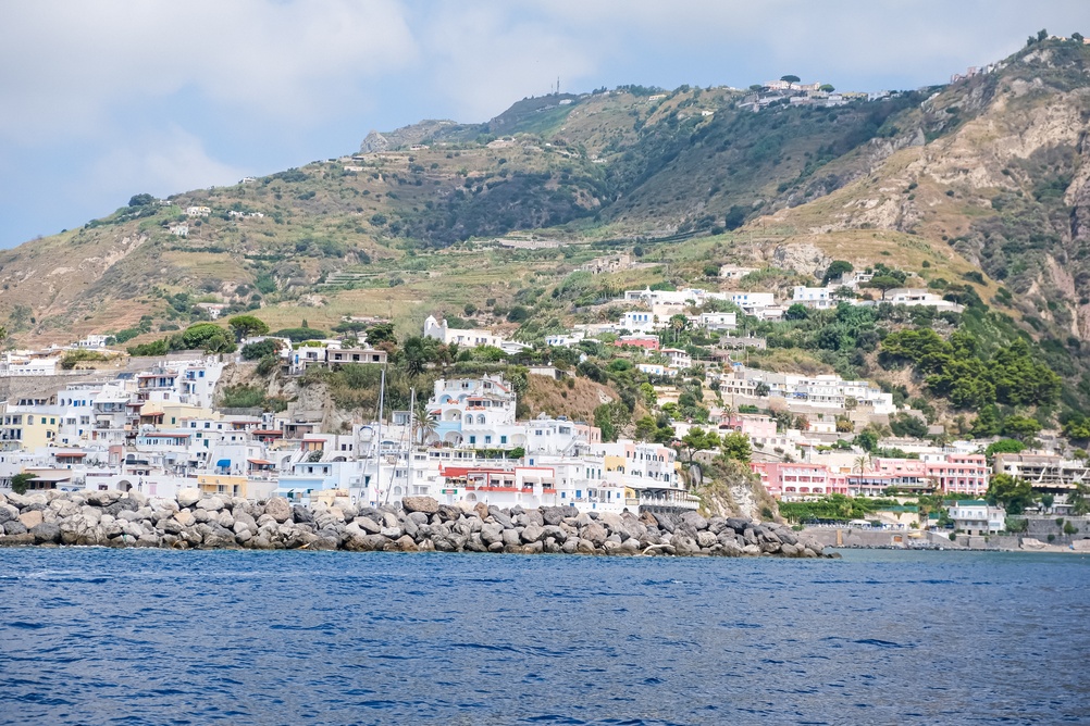 Färgglada hus och stenpiren i Sant'Angelo på Ischia