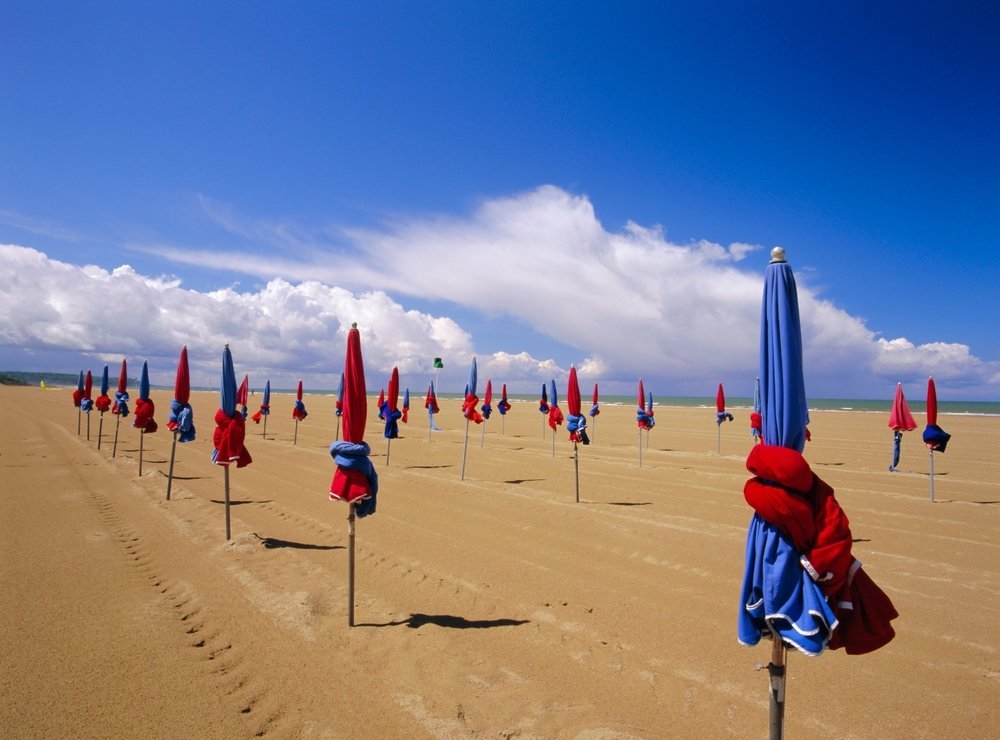 De färgglada parasollerna på stranden i Deauville i Normandie
