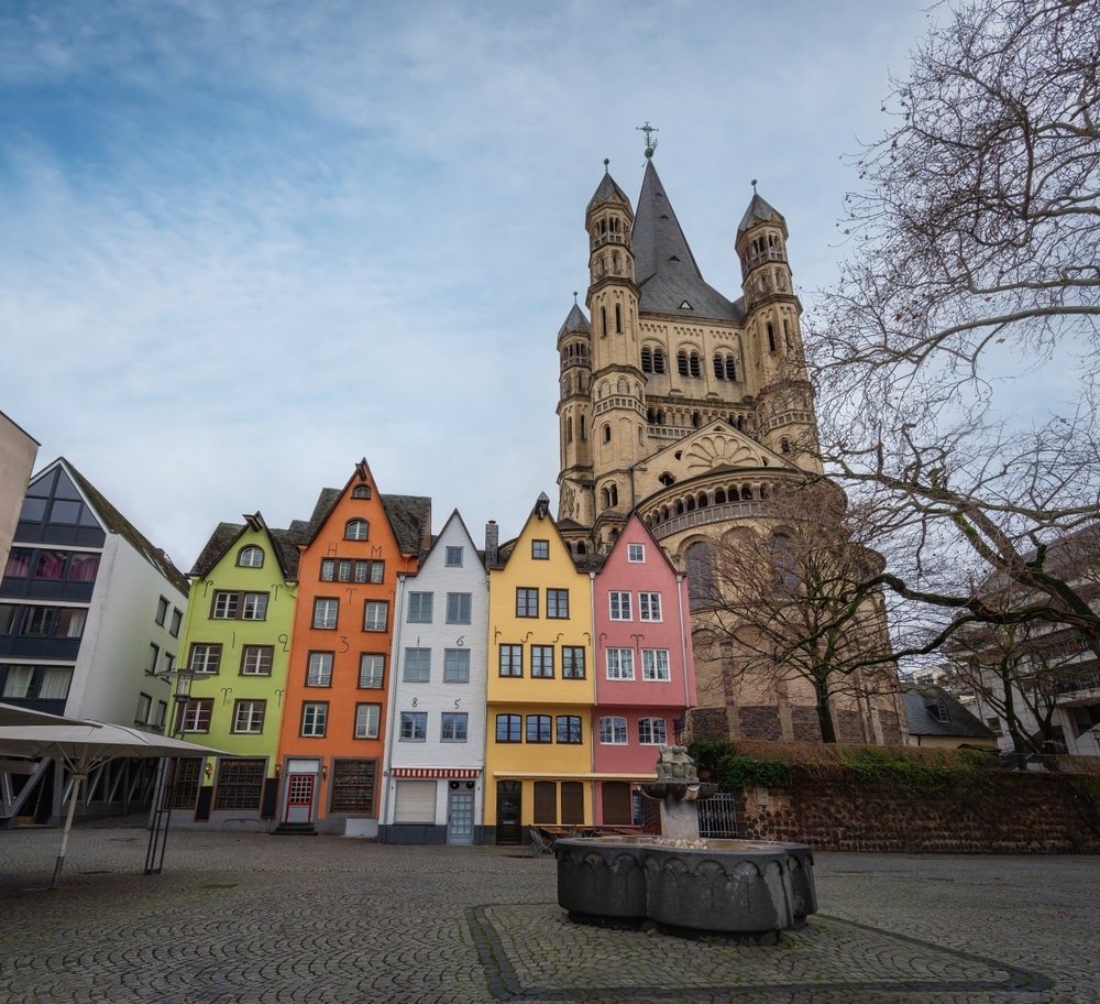 Fischmarkt med de färgglada husen och kyrkan Groß St. Martin i Kölns Old Town