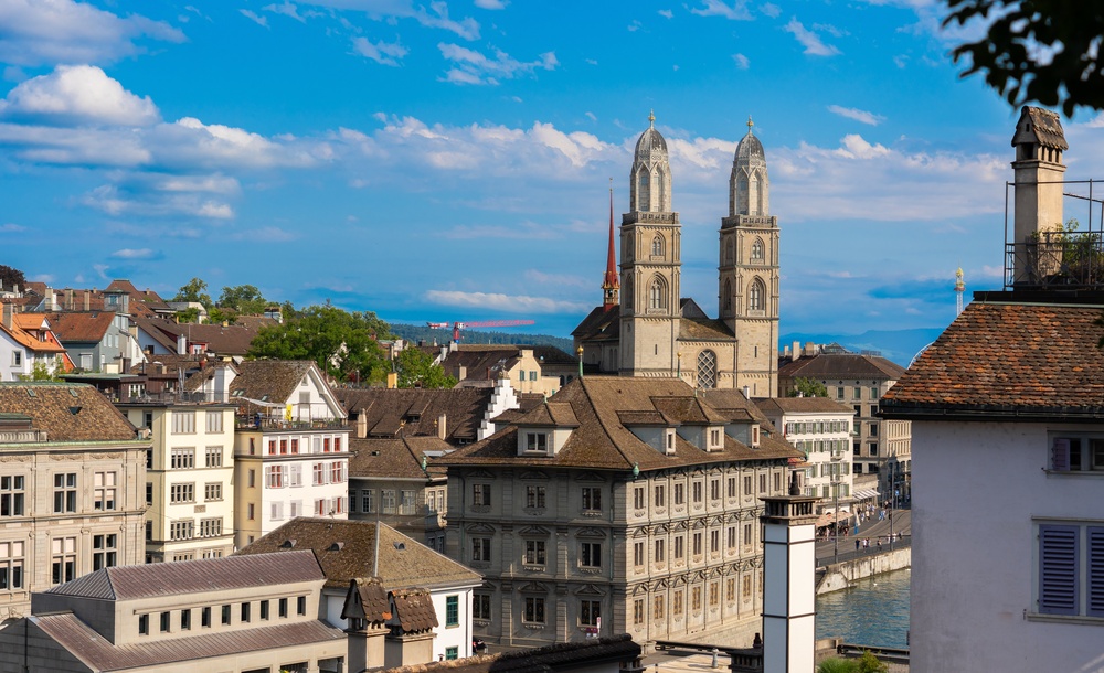 Gamla stan i Zürich med gamla hustak och katedralen Grossmünster