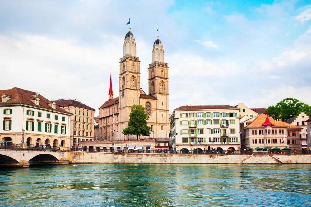 Grossmünster med sina två torn vid floden Limmat i Zürich