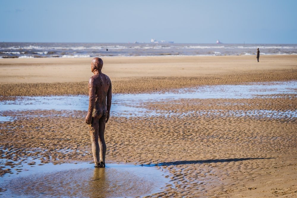 Järnfigurer från Another Place av Antony Gormley på Crosby Beach