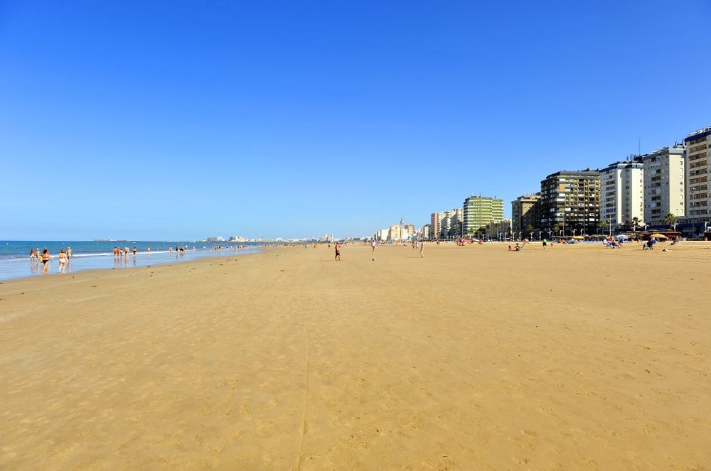 Den långa sandstranden Playa de la Victoria i Cádiz med strandpromenaden