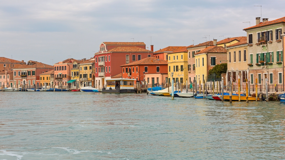 Färgglada hus längs en kanal på Murano vid Venedig