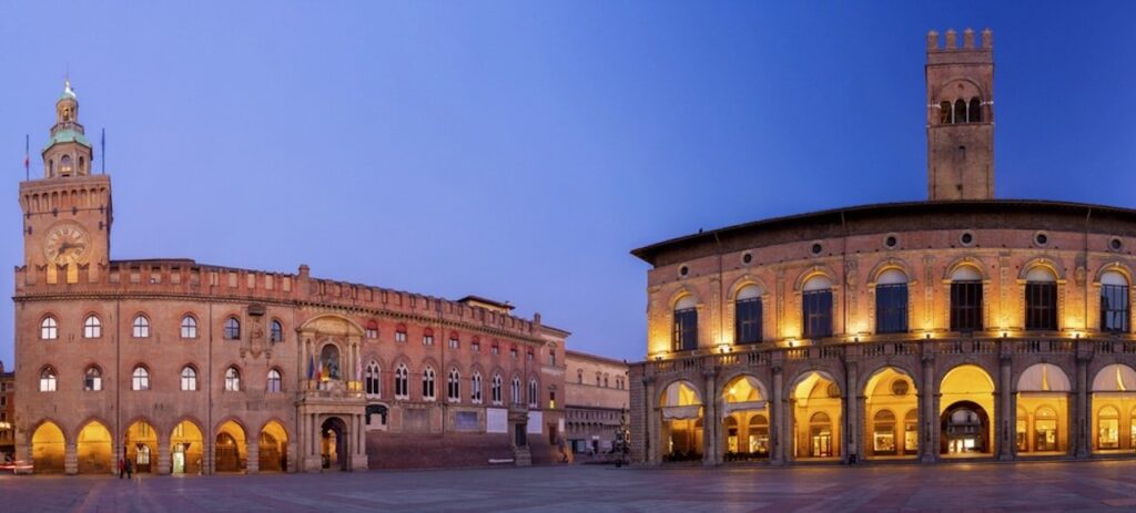 Piazza Maggiore med Palazzo d'Accursio och Palazzo del Podestà i Bologna på kvällen