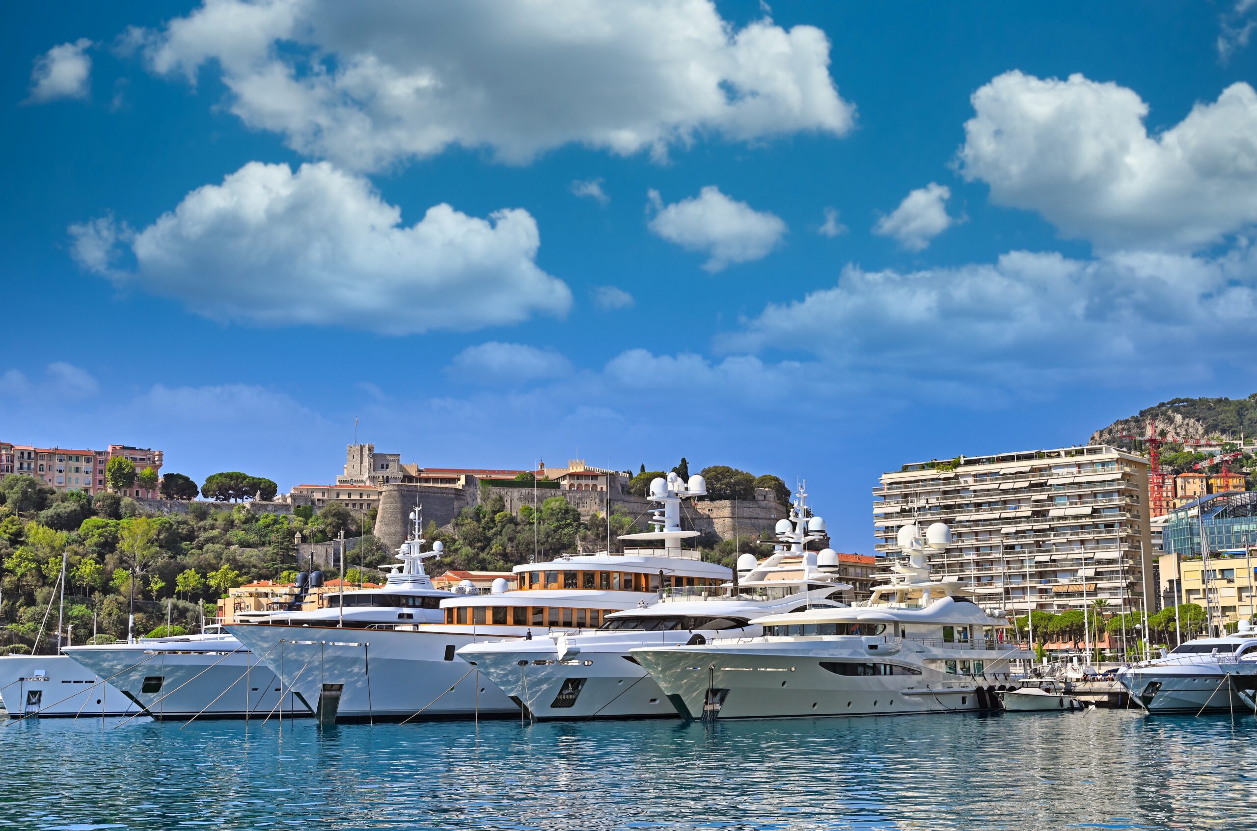 Yachter i Port Hercule i Monaco med furstepalatset i bakgrunden