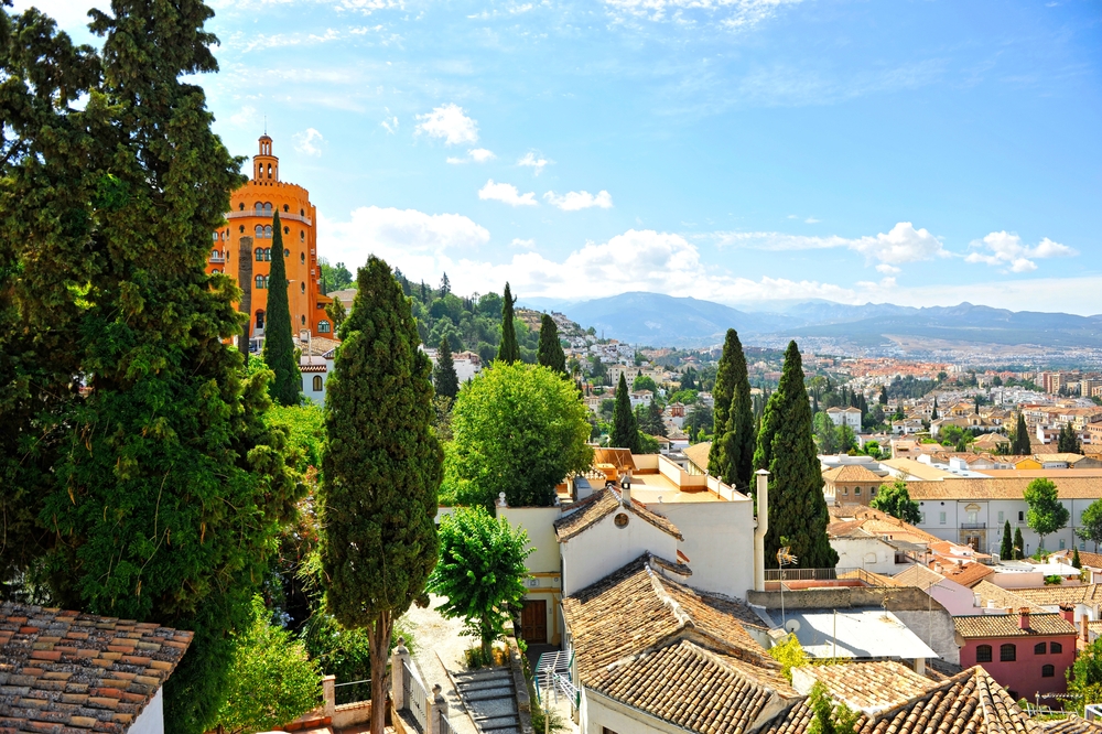 Panorama över kvarteret El Realejo i Granada med Sierra Nevada i bakgrunden
