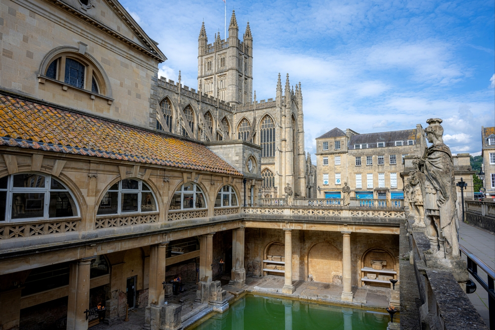 De historiska Roman Baths i centrala Bath med Bath Abbey i bakgrunden