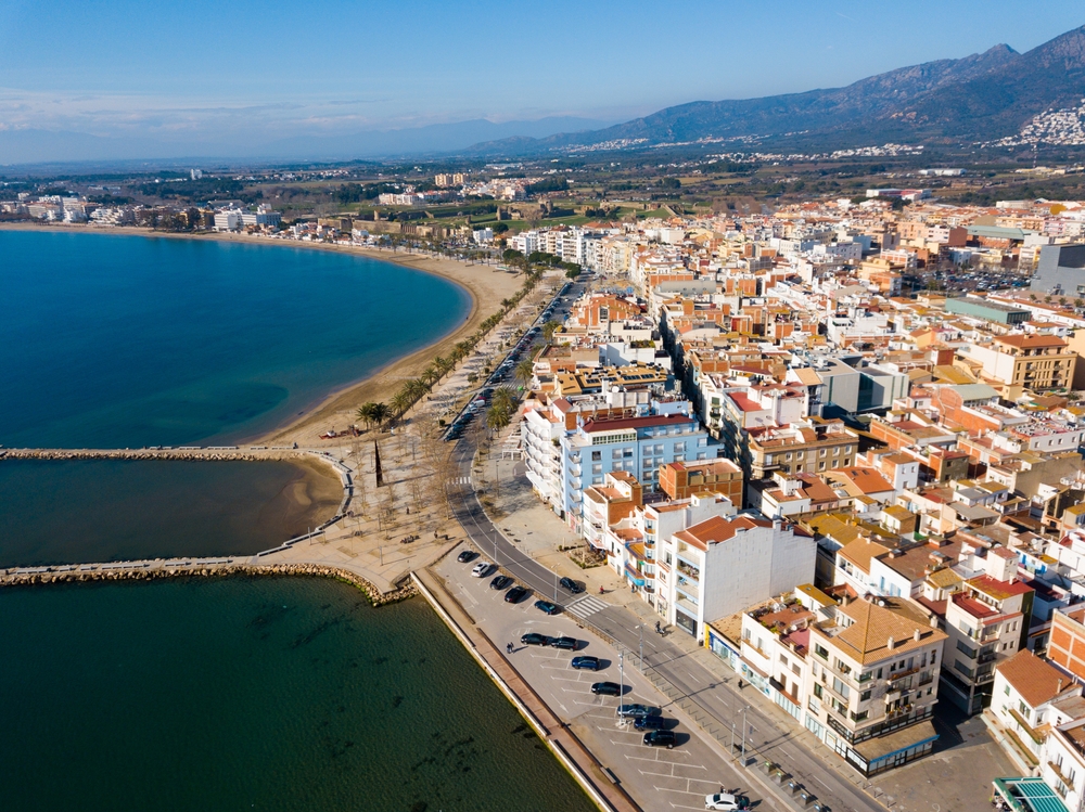 Semesterorten Roses på Costa Brava sedd från luften med stranden och promenaden