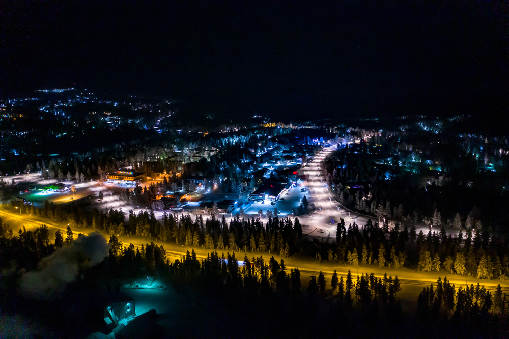Flygbild över Saariselkä på kvällen med färgglada ljus i Lappland