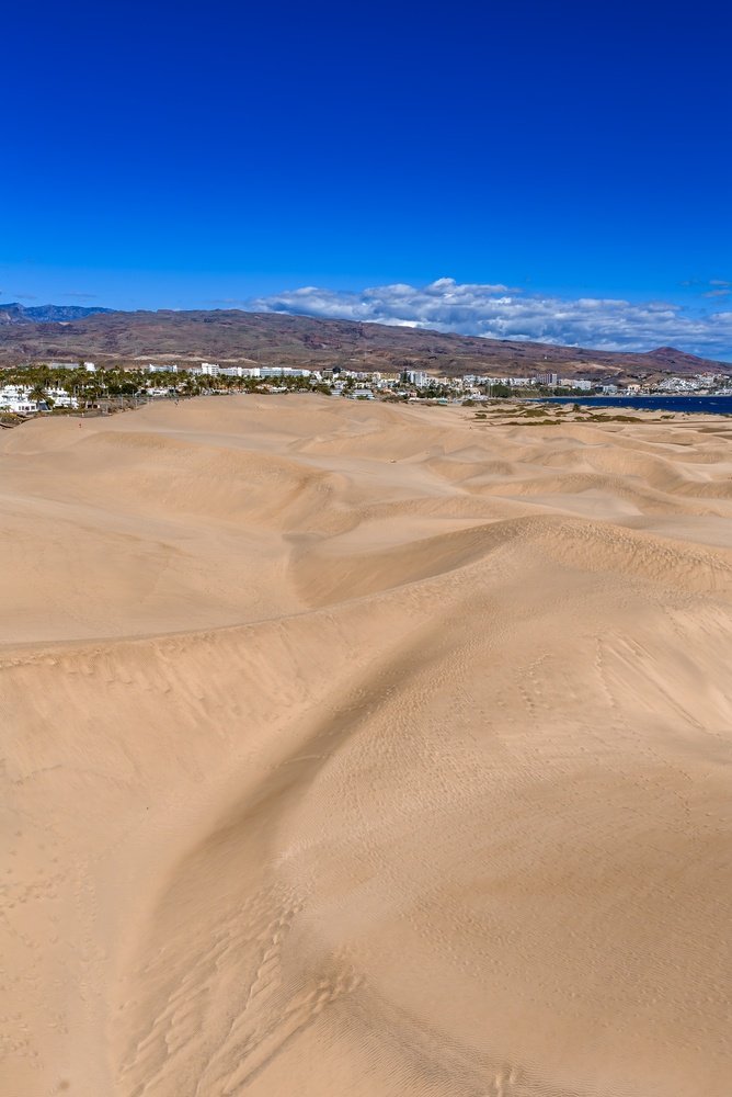 Sanddynerna vid Maspalomas med hotellen i Playa del Inglés