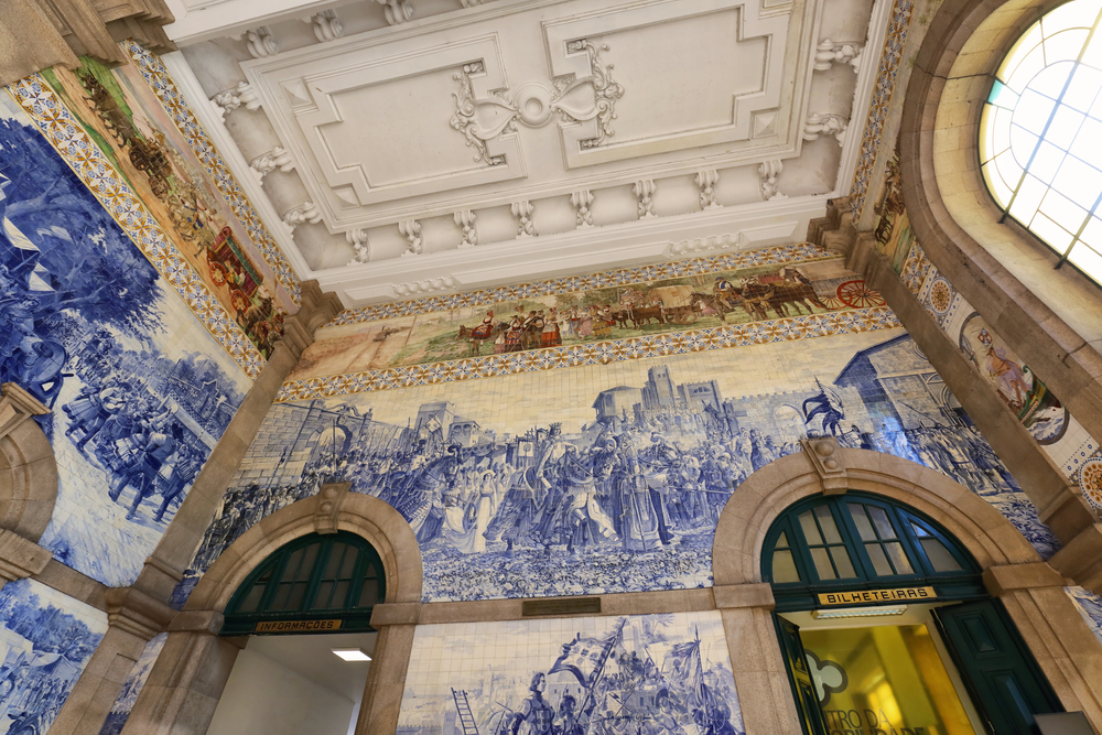 Blåvita azulejoplattor på väggarna i stora hallen på São Bento-stationen i Porto