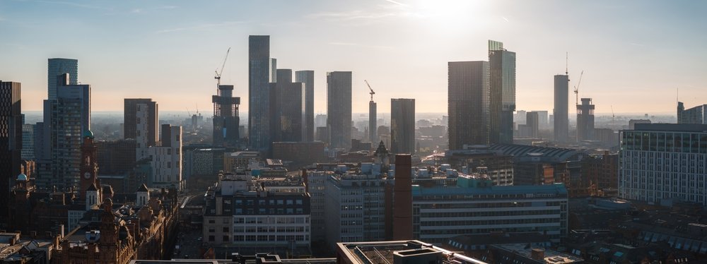 Manchesters centrum sett från luften med skyskrapor och röda tegelbyggnader