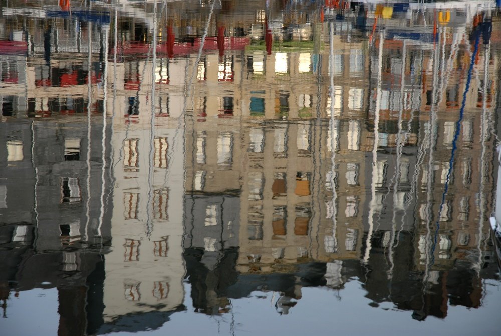 De smala husen runt den gamla hamnen Vieux Bassin i Honfleur som speglas i vattnet