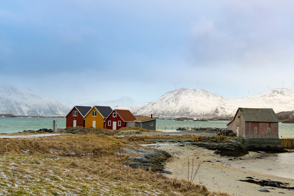 Vinterlandskap på Sommarøy med rorbuer vid vattnet