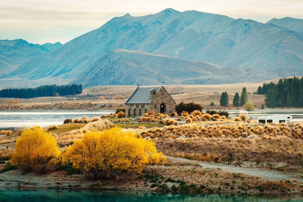 Stenkyrkan Church of the Good Shepherd vid Lake Tekapo med bergen i bakgrunden
