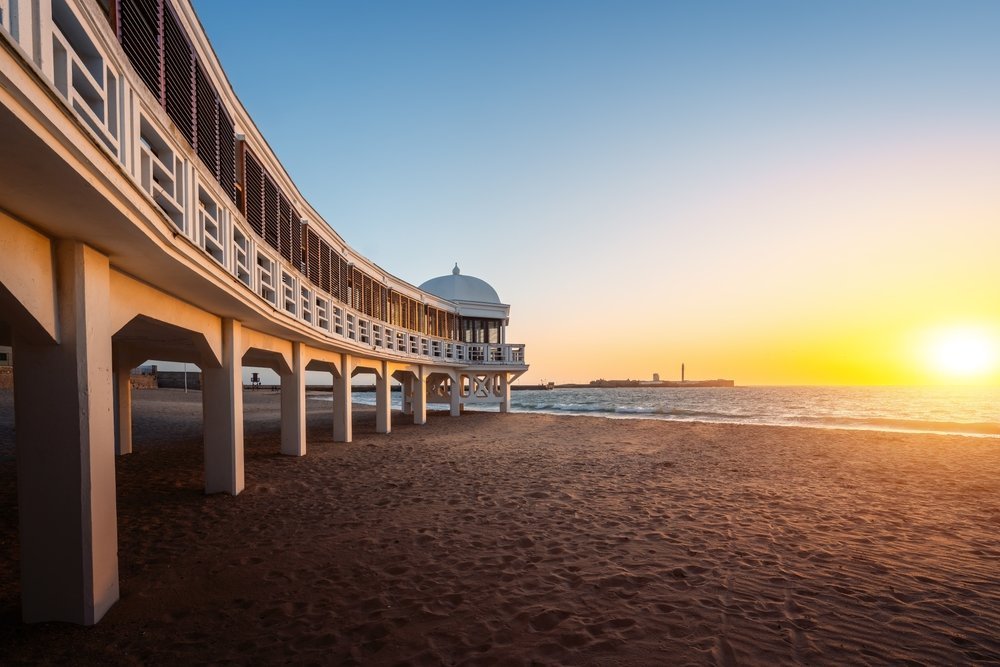 Stranden La Caleta i Cádiz med badhuset Balneario de la Palma i solnedgången