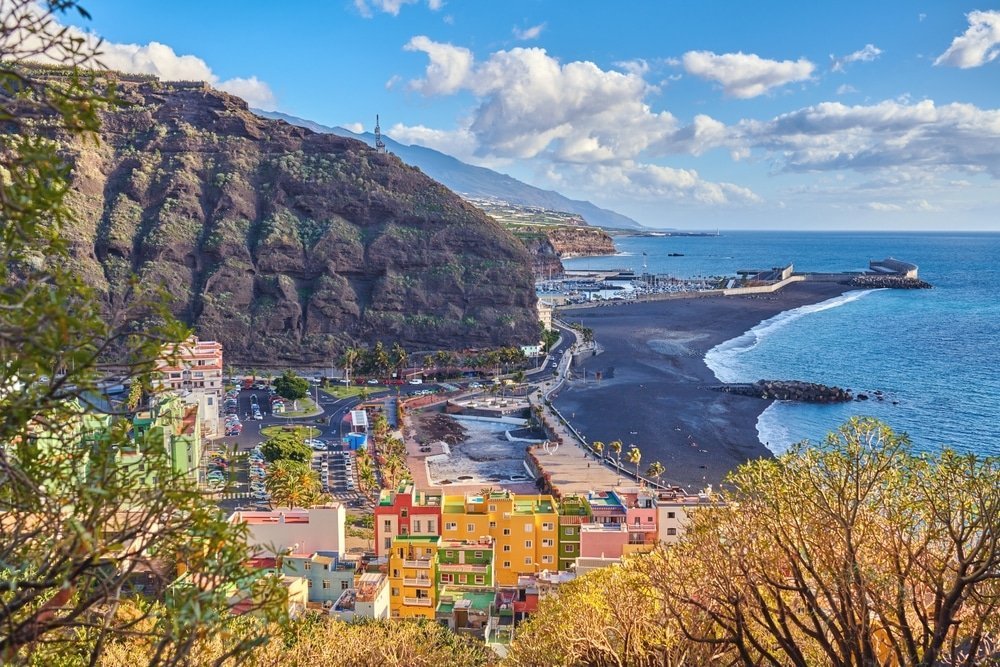 Stranden med svart sand och husen i Puerto de Tazacorte på La Palma