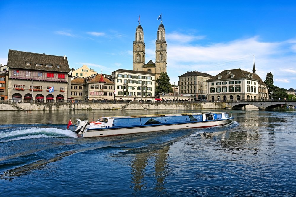 Turistbåt på Limmat i Zürich med Grossmünster i bakgrunden