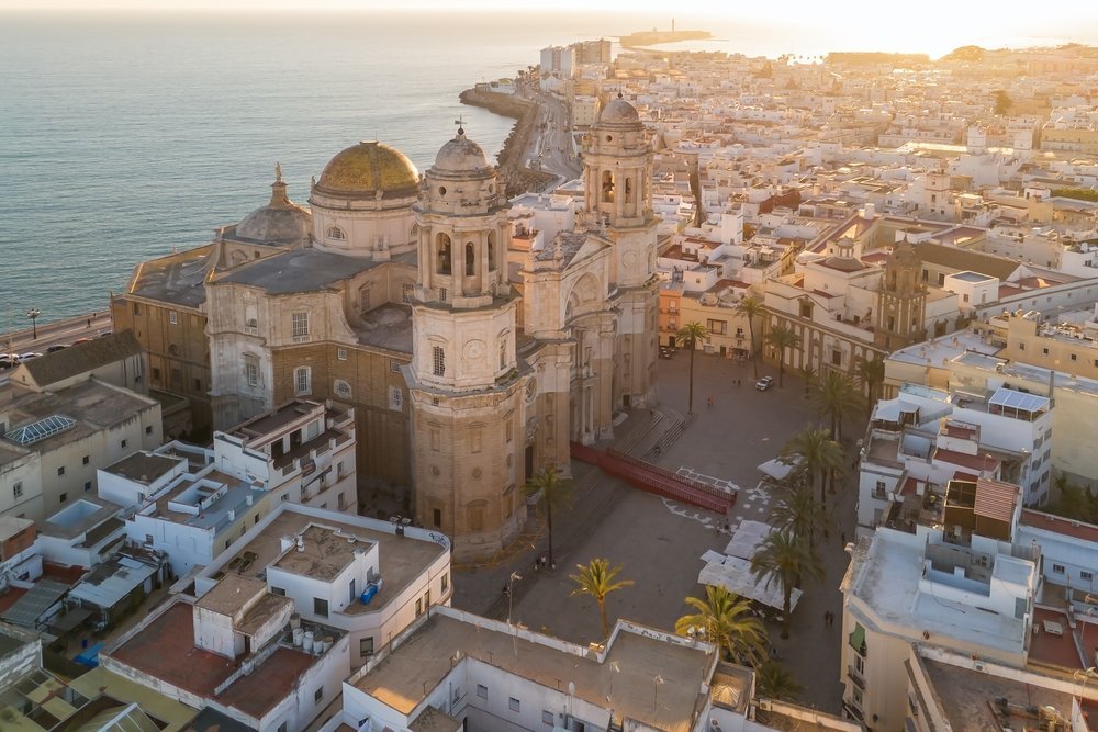 Flygfoto över katedralen och Old Town i Cádiz vid solnedgången med Atlanten i bakgrunden