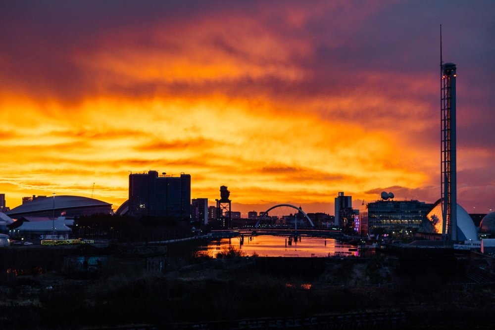 Glasgows skyline vid solnedgången sedd över floden Clyde