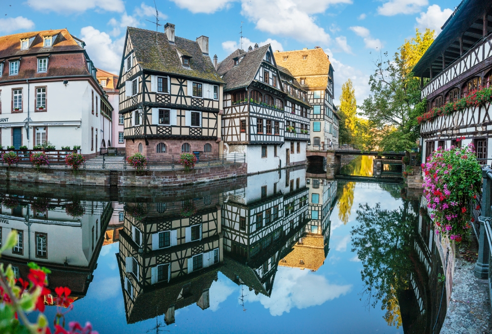 Korsvirkeshus i Petite France som speglas i kanalerna i Strasbourg