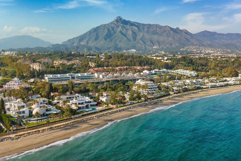 Villor och hotell vid stranden på Golden Mile i Marbella med berget La Concha